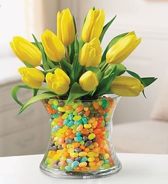 Bright tulips in a vase full of jelly beans
